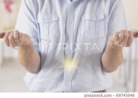 Man dowsing wirh dividing rod to locate ground water Man dowsing wirh dividing rod to locate ground water 69745046