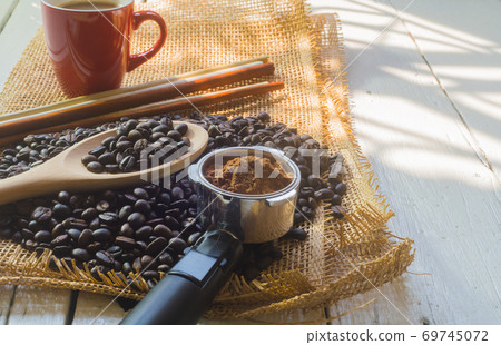Red coffee cup and coffee bean on white wooden desk in morning Red coffee cup and coffee bean on white wooden desk in morning 69745072