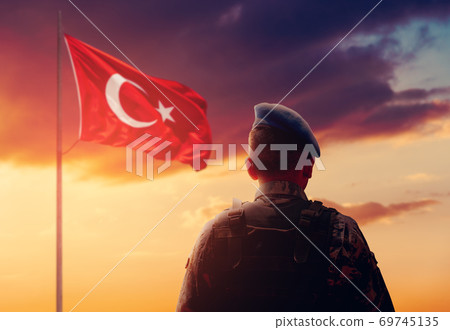Turkish Soldier is stand and salute front of Turkish Flag on his watch duty. Turkish Soldier is stand and salute front of Turkish Flag on his watch duty. 69745135