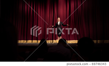 Female caucasian speaker giving presentation in hall at university or business centre workshop 69746343