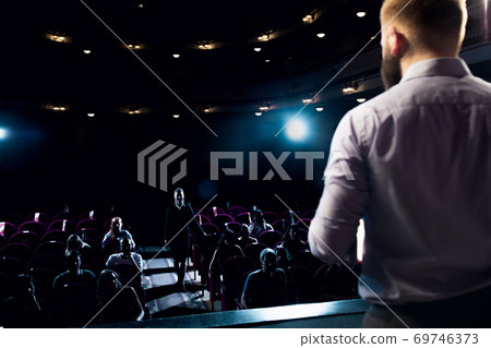Male caucasian speaker giving presentation in hall at university or business centre workshop Male caucasian speaker giving presentation in hall at university or business centre workshop 69746373