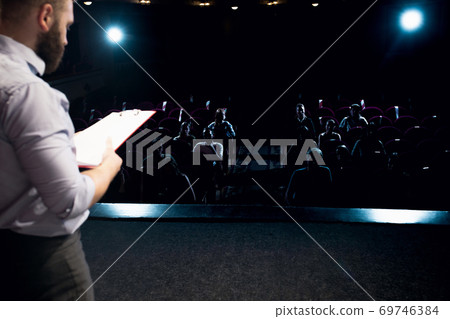 Male caucasian speaker giving presentation in hall at university or business centre workshop Male caucasian speaker giving presentation in hall at university or business centre workshop 69746384