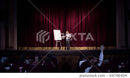 Male caucasian speaker giving presentation in hall at university or business centre workshop Male caucasian speaker giving presentation in hall at university or business centre workshop 69746404