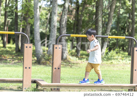 Boy playing on balance beam 69746412