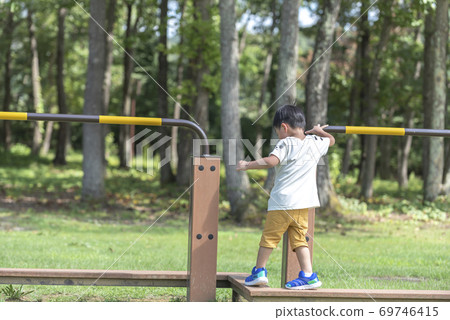Boy playing on balance beam 69746415