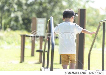 A boy playing with park play equipment A boy playing with park play equipment 69747326