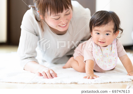 一位母親抱著一個嬰兒是 69747613