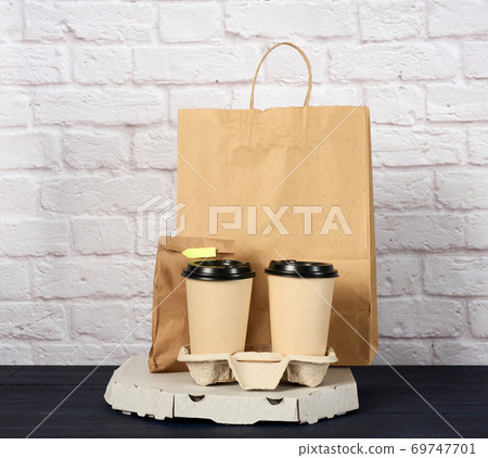 white cardboard box with pizza and disposable paper cups with coffee in holder 69747701