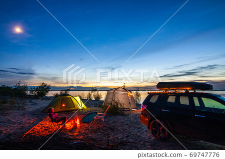 Little girl sitting at bonfire in tourist camping  in the evening 69747776