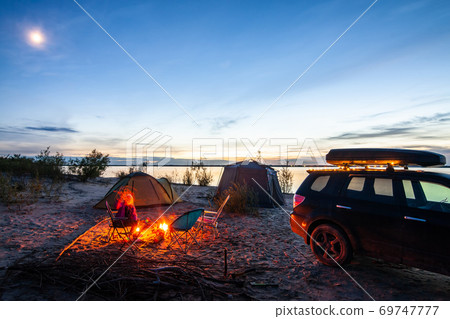 Tourist camping at the river on the sunset Tourist camping at the river on the sunset 69747777