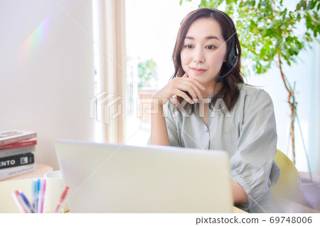 Woman having an online meeting in the living room 69748006