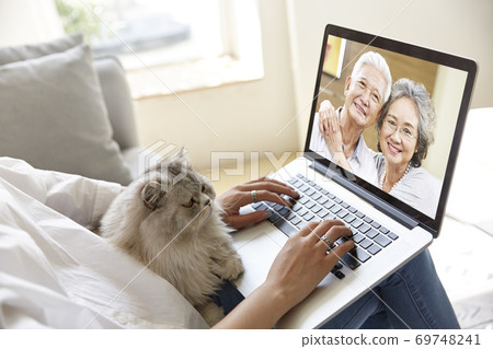 young asian woman talking chatting with parents via video call using laptop computer young asian woman talking chatting with parents via video call using laptop computer 69748241