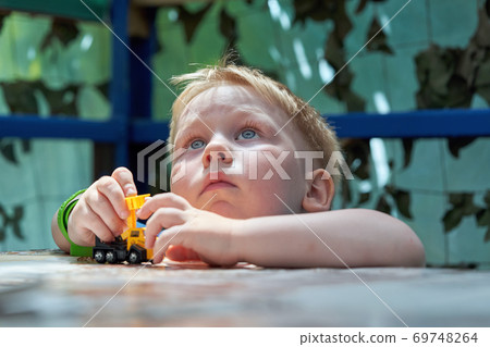 Portrait of a child of three years old playing a typewriter and looking up Portrait of a child of three years old playing a typewriter and looking up 69748264