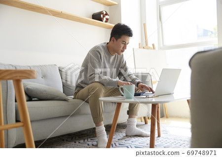 young asian corporate executive staying at home working using laptop computer 69748971
