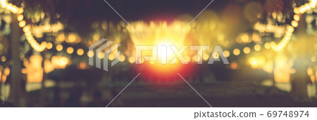 blurred bokeh light on sunset with yellow string lights decor in beach restaurant blurred bokeh light on sunset with yellow string lights decor in beach restaurant 69748974