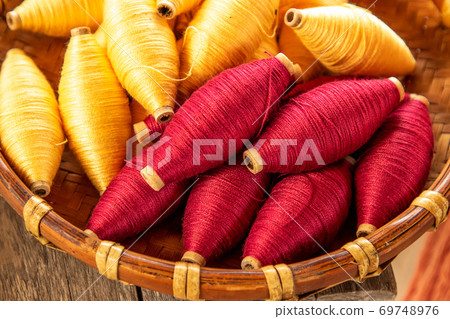 natural colour of red and yellow cotton spools of thread use for weaving textile with tradition loom 69748976