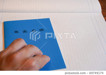 Blue pension book cover and left hand Blue pension book cover and left hand 69749174