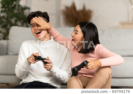 Happy Korean Boyfriend And Girlfriend Playing Video Games At Home Happy Korean Boyfriend And Girlfriend Playing Video Games At Home 69749179