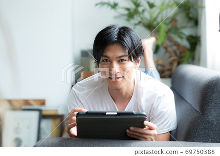 在沙發上的平板電腦上寫一個人 在沙發上的平板電腦上寫一個人 69750388