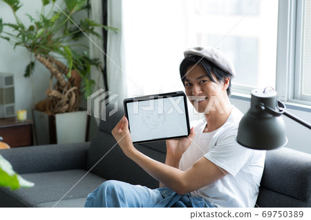 在沙發上的平板電腦上寫一個人 在沙發上的平板電腦上寫一個人 69750389