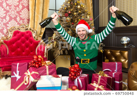 Man in santa hat smile with champagne bottles 69750848