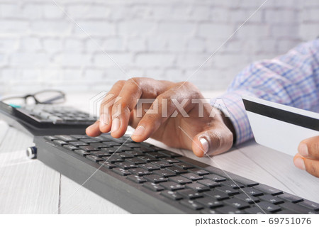 man hands holding credit card and using keyboard shopping online man hands holding credit card and using keyboard shopping online 69751076