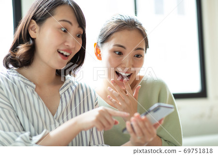 Two women looking at their smartphones 69751818