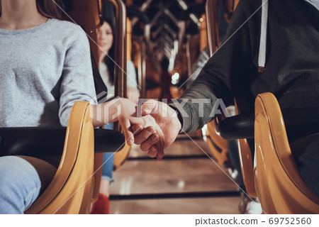 Couple holding hands before ride on roller coaster Couple holding hands before ride on roller coaster 69752560