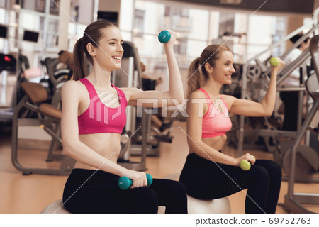 Girls are smiling and doing exercise. Girls are smiling and doing exercise. 69752763