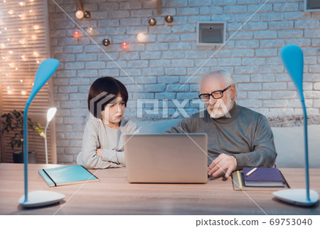 Grandfather and grandson learn to work at laptop. 69753040