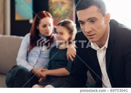 A man sits in a suit and looks down. A man sits in a suit and looks down. 69753041