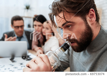 Man drink alcohol with family at psychologist. 69753074