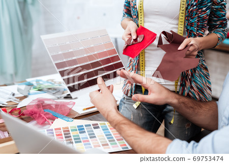 Two fashion designers looking at color swatches. 69753474