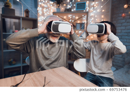 Grandfather and grandson are using virtual reality 69753476