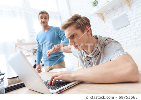 Father distracts son from video game at home. 69753665