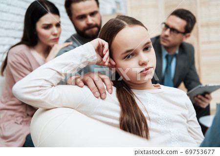 Adult bearded father tries to get attention of small daughter at doctor acception. 69753677