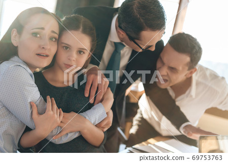 Mom hugs daughter and they are afraid dad.  69753763