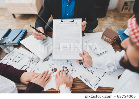 Arab holds a contract in his hands. Arab holds a contract in his hands. 69754006