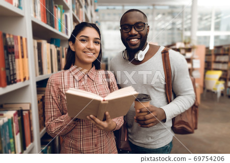Ethnic mixed race girl and black guy in library.  69754206