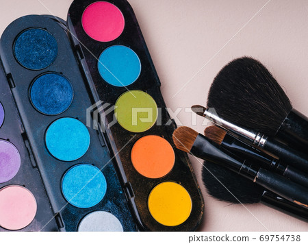 makeup brushes and brightly coloured palette with shades for painting eyes 69754738