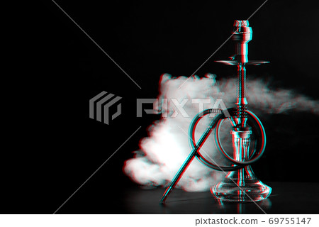 Hookah with coals and smoke on the table in a restaurant Hookah with coals and smoke on the table in a restaurant 69755147
