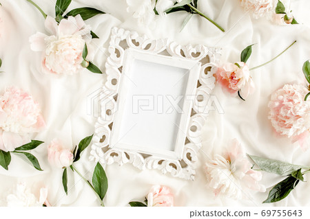 Carved, white frame decorated of beautiful and beige peonies. Flat lay, top view. Valentine's background. Floral frame. Peony texture. Carved, white frame decorated of beautiful and beige peonies. Flat lay, top view. Valentine's background. Floral frame. Peony texture. 69755643