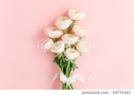 Pastel pink ranunculus flowers bouquet on pink background. Minimal floral concept. Flat lay, top view. Pastel pink ranunculus flowers bouquet on pink background. Minimal floral concept. Flat lay, top view. 69756361