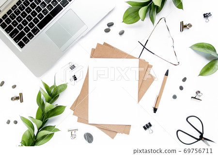 office desk workspace with paper blank, green leaves. Laptop, glasses on white background. Magazines, websites, social media. Flat lay, top view. office desk workspace with paper blank, green leaves. Laptop, glasses on white background. Magazines, websites, social media. Flat lay, top view. 69756711
