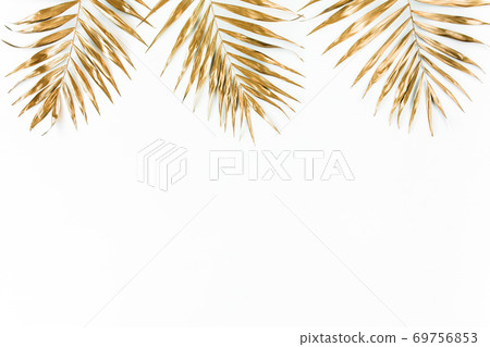Gold tropical palm leaves on white background. Flat lay, top view minimal concept. Gold tropical palm leaves on white background. Flat lay, top view minimal concept. 69756853