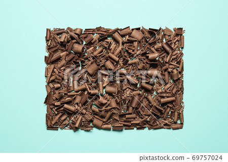 Chocolate pieces pile isolated on blue background. Chopped chocolate top view 69757024