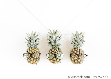 Hipster pineapples in glasses on white background. Flat lay, top view 69757455