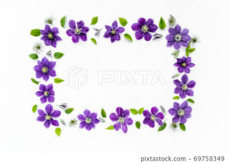 Floral frame with space for text made of purple flowers, green leaves and branches on a white background. The apartment lay, top view. Floral frame with space for text made of purple flowers, green leaves and branches on a white background. The apartment lay, top view. 69758349