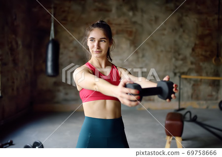 Girl lifting dumbbells in gym during workout. Young woman doing fitness. Healthy lifestyle Girl lifting dumbbells in gym during workout. Young woman doing fitness. Healthy lifestyle 69758666