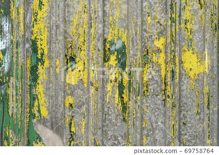 Old corrugated iron fence with peeling green and yellow paint. Abstract texture Old corrugated iron fence with peeling green and yellow paint. Abstract texture 69758764